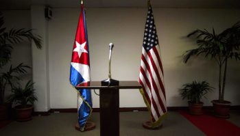 A Cuban flag and an American flag stand in the press room during the second day of talks between U.S. and Cuban officials, in Havana, Cuba, Thursday, Jan. 22, 2015. The United States and Cuba are trying to eliminate obstacles to normalized ties as the highest-level U.S. delegation to the communist island in more than three decades holds a second day of talks with Cuban officials. (AP Photo/Ramon Espinosa)