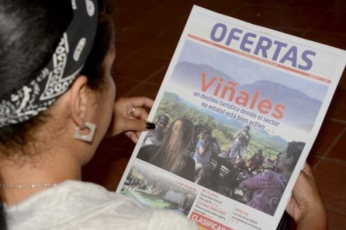 Asistente a la XXVI Feria Internacional del Libro de La Habana lee el periódico Ofertas, durante su presentación en la fortaleza San Carlos de La Cabaña (Foto: Rafael Fernández Rossel /ACN)