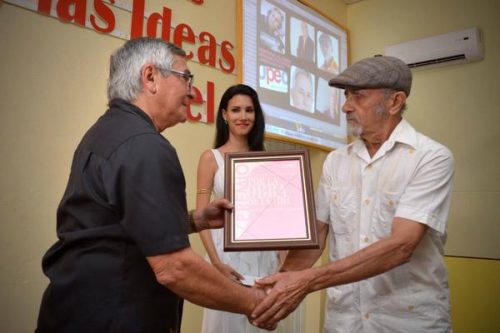 Félix Hernández (I), presidente de la delegación provincial de la Unión de Periodistas de Cuba (UPEC), entrega al periodista Félix Ramón Lobaina, de la emisora La voz del níquel, de Moa, el premio por la obra de la vida Abraham Portuondo Larrasagui, durante el acto por el Día de la Prensa Cubana en la provincia de Holguín (Foto: Juan Pablo Carreras/ ACN)