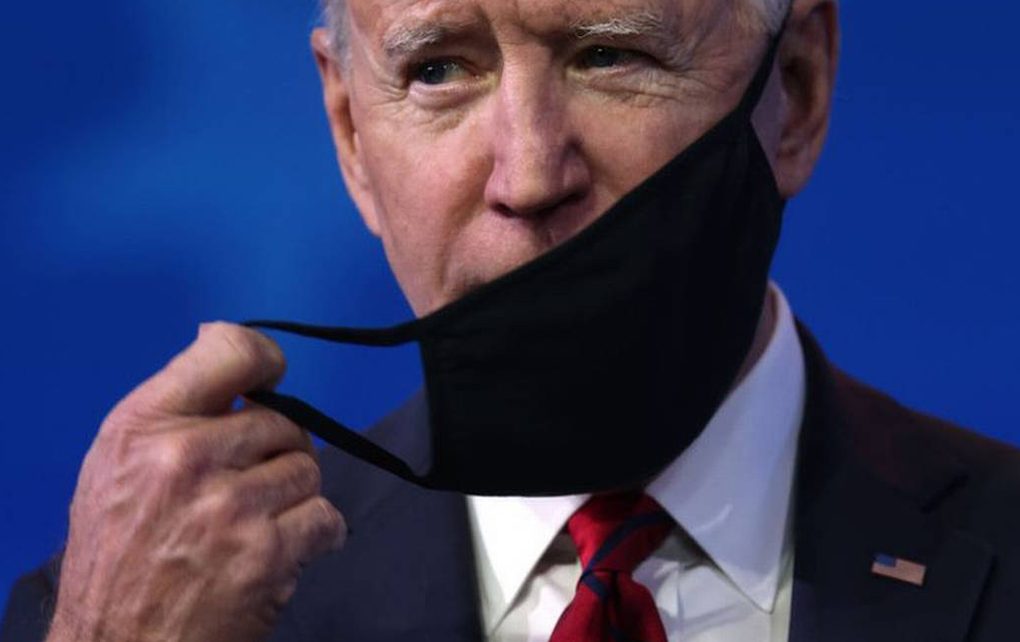 Joe Biden quitandose la mascarilla